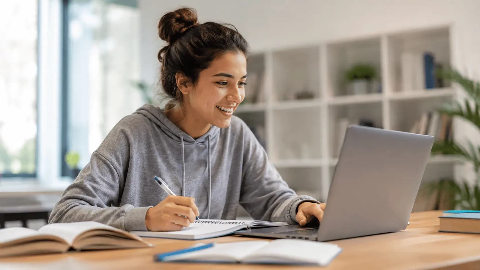 Joven estudiando con su notebook y tomando apuntes